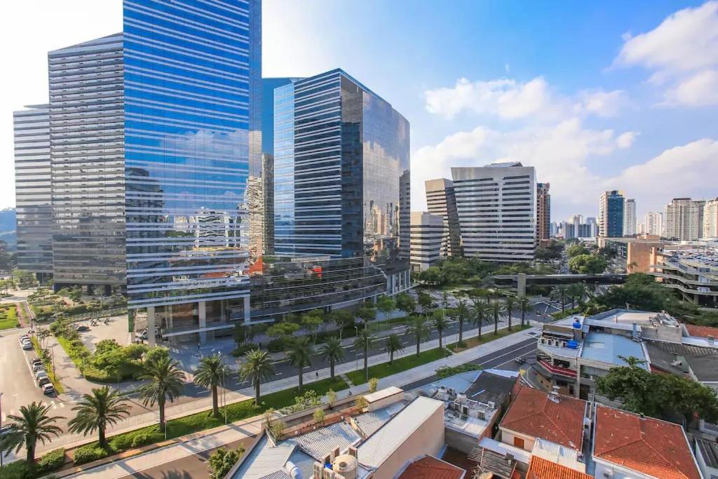 una ciudad con edificios altos y una calle con palmeras en Estúdio no Add Nova Berrini - 512, en São Paulo