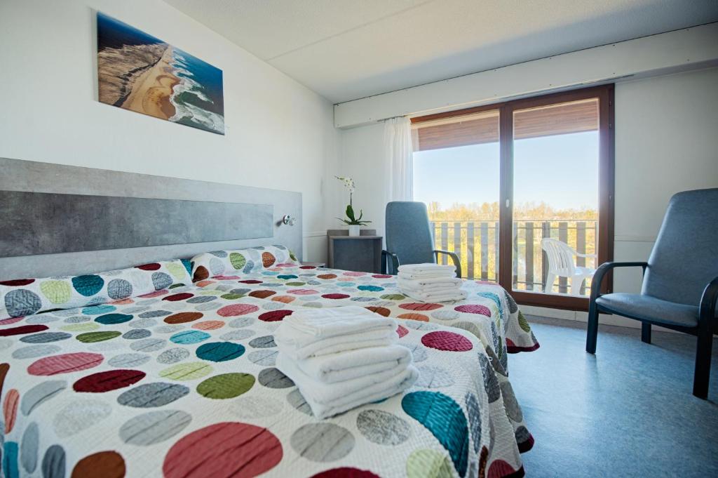 sypialnia z łóżkiem z ręcznikami w obiekcie Résidence Espace Thermal w mieście Dax