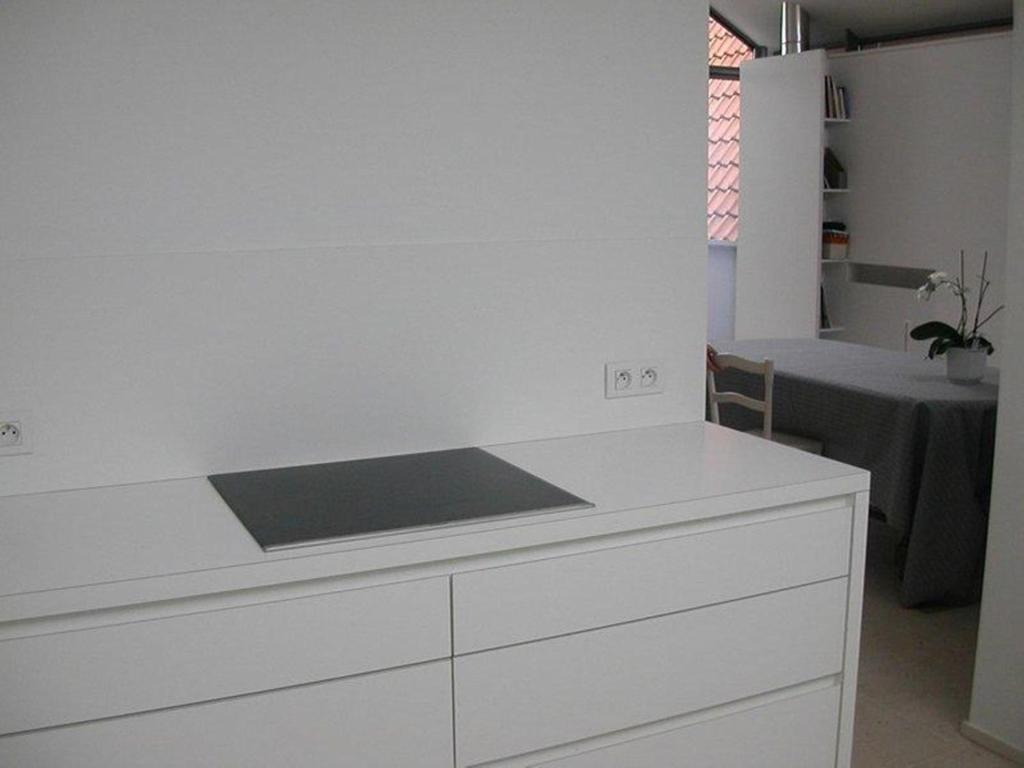 a kitchen with a white counter top and a table at B&B 't Walleke in Bruges
