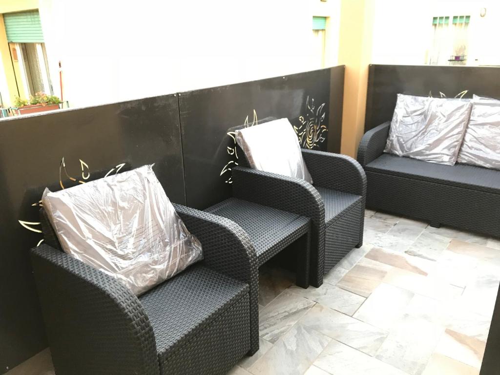 duas cadeiras de vime e um banco com duas almofadas em B&B ATTICO GALLIERA em Bolonha