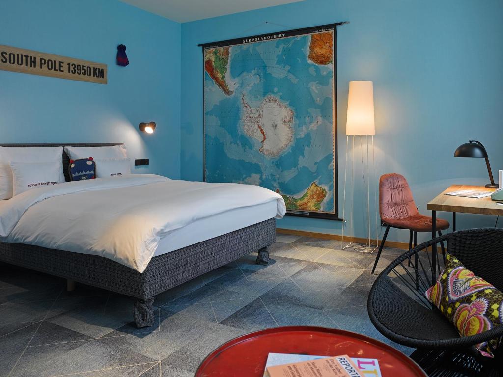 ein Schlafzimmer mit einem Bett und einer Karte an der Wand in der Unterkunft 25hours Hotel The Trip in Frankfurt am Main