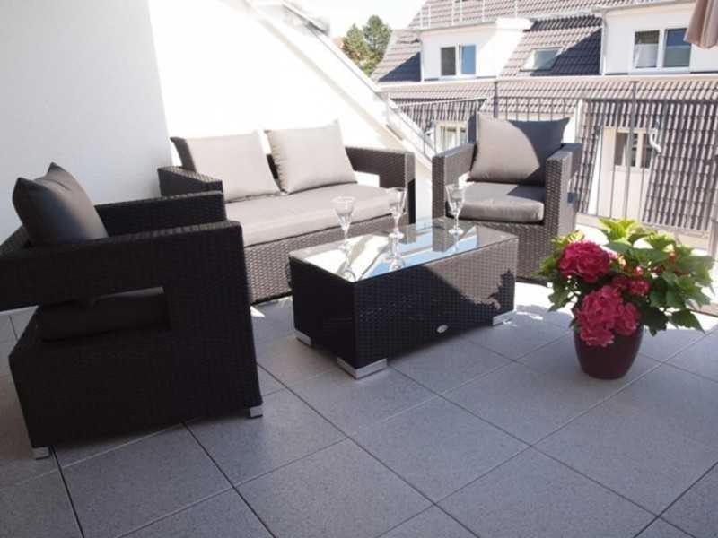 a patio with two couches and a table and flowers at Ferienwohnung Angelika _ Peter Kel in Scharbeutz