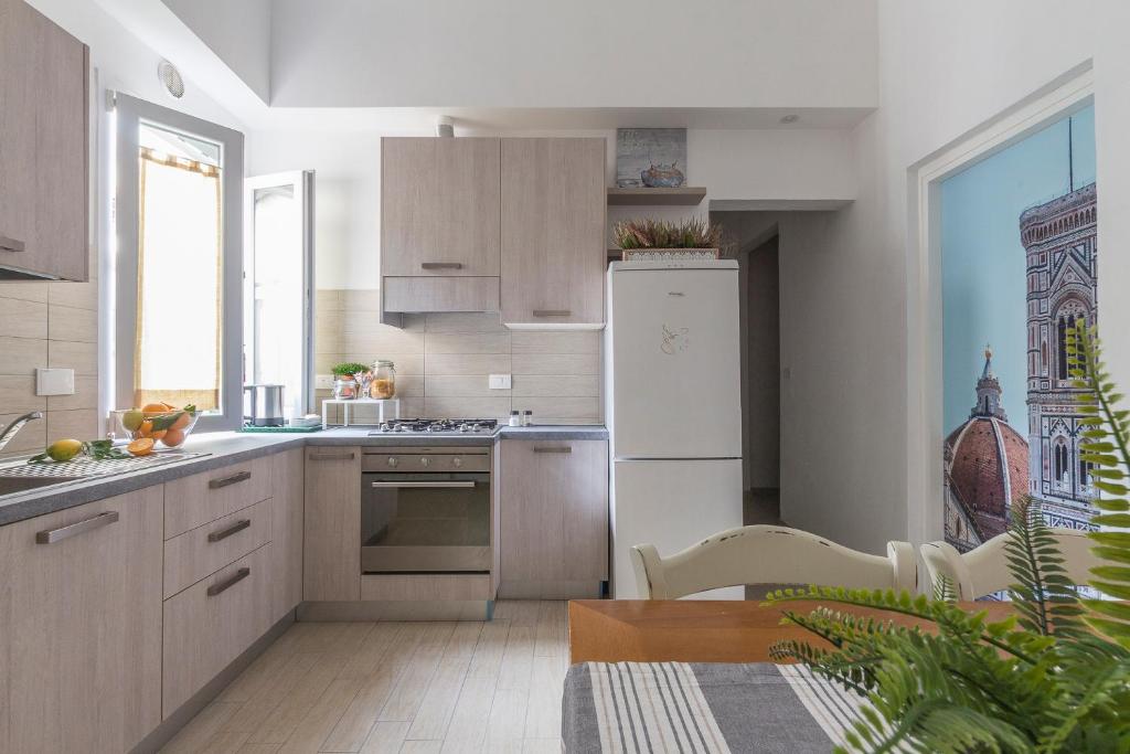 a kitchen with a white refrigerator and a table at Emma & Olga Apartments -In the city Centre- in Florence