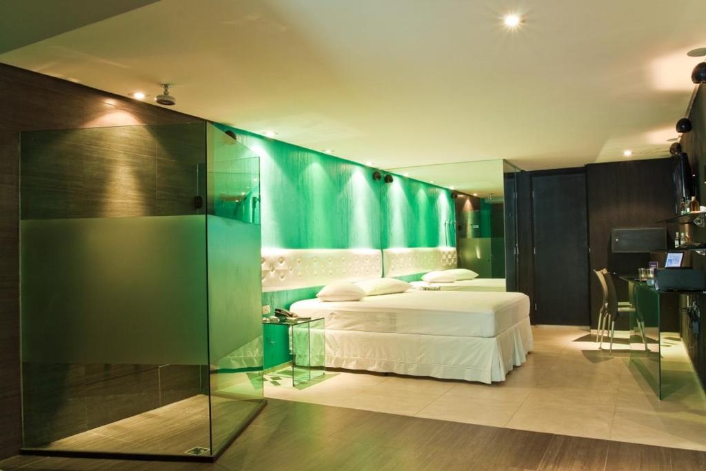 1 dormitorio con 2 camas y pared de cristal en Forum Motel, en Recife