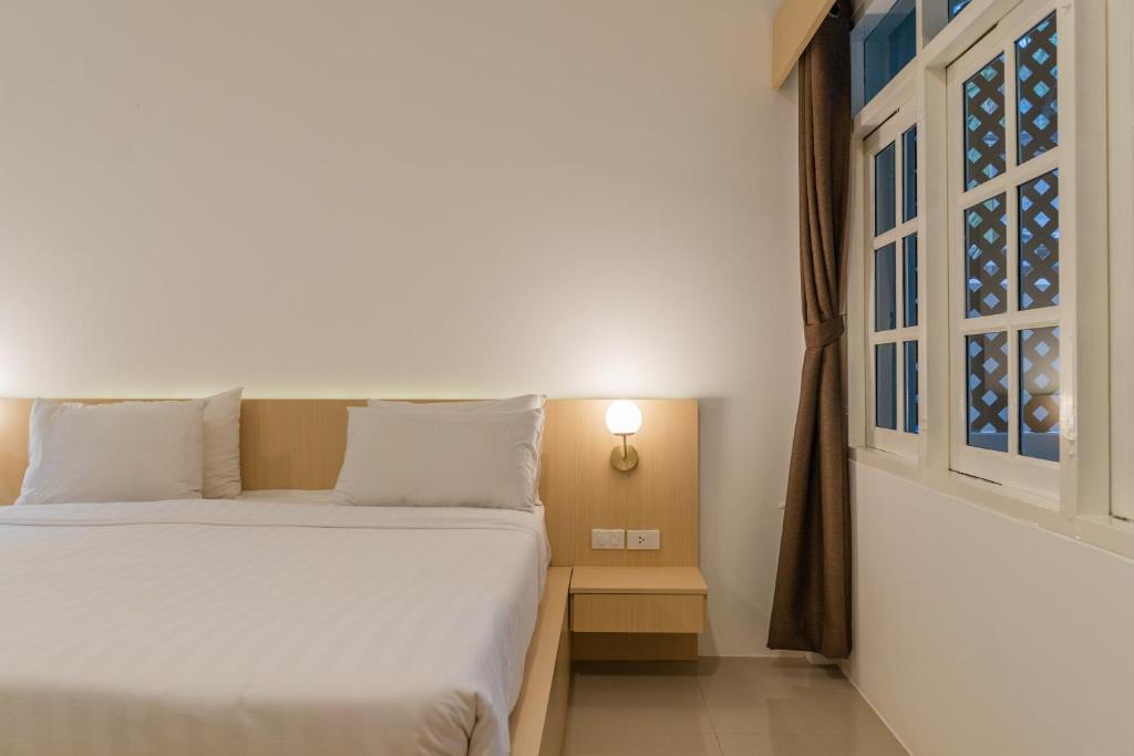 a bedroom with two beds and a window at Garden Home Kata in Kata Beach