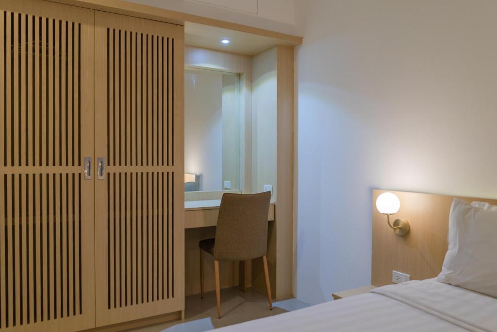 a bedroom with a bed and a desk with a chair at Garden Home Kata in Kata Beach