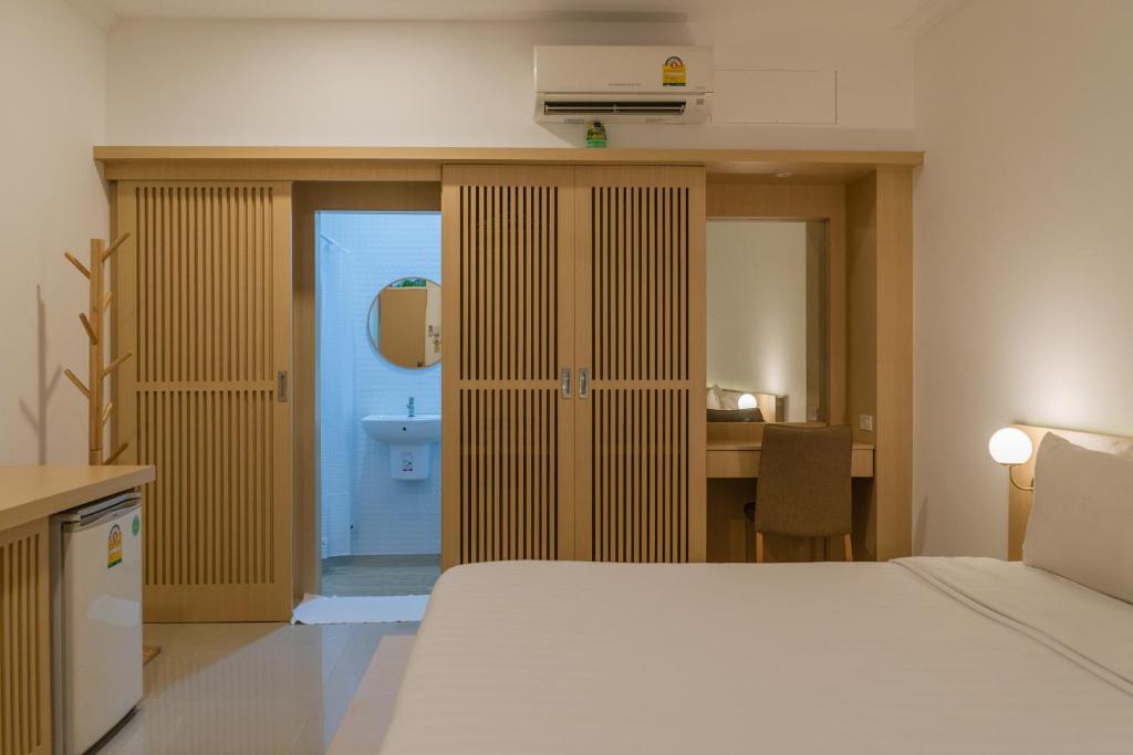a bedroom with a bed and a desk and a room at Garden Home Kata in Kata Beach