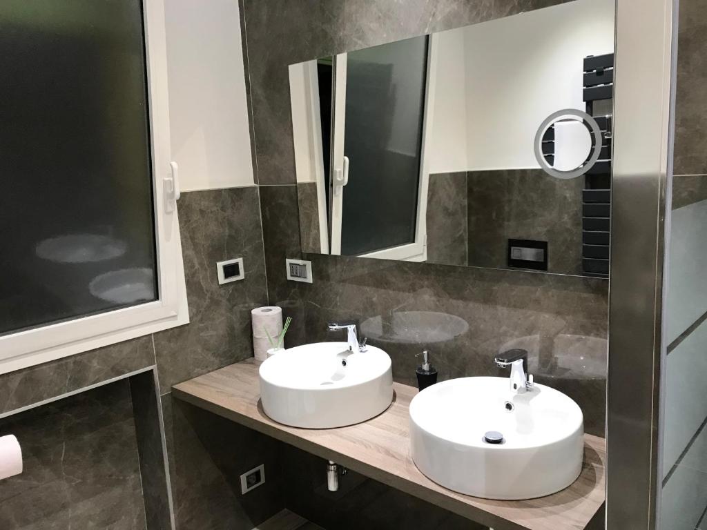 łazienka z 2 umywalkami i lustrem w obiekcie B&B ATTICO GALLIERA w Bolonii
