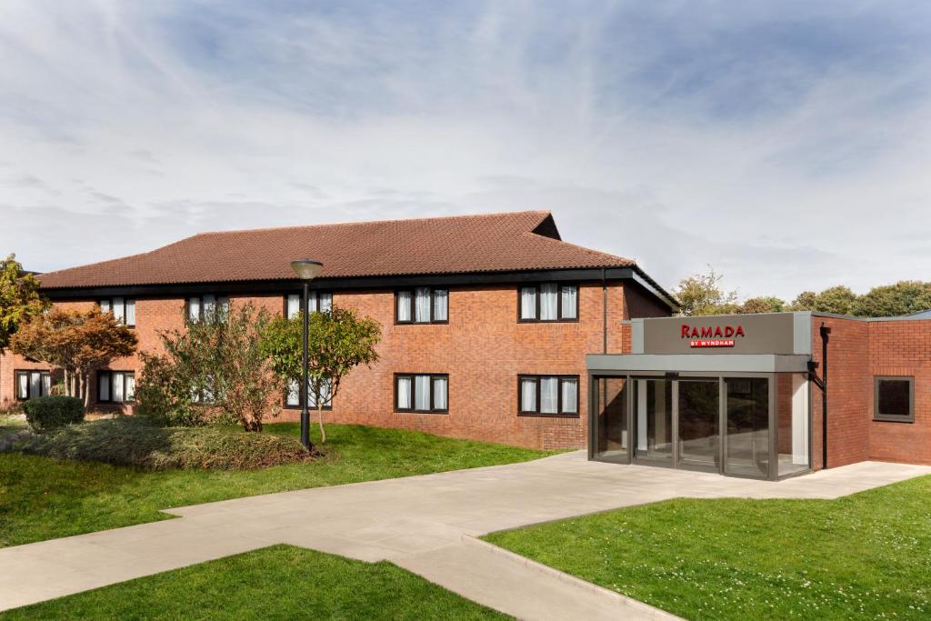 a red brick building with a duluth sign in front at Ramada Bristol West in Easton in Gordano