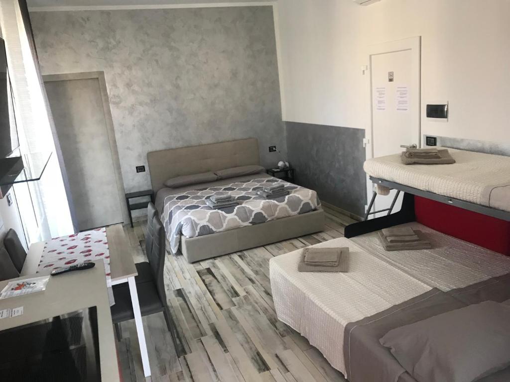 mały pokój z 2 łóżkami i 2 stołami w obiekcie B&B ATTICO GALLIERA w Bolonii