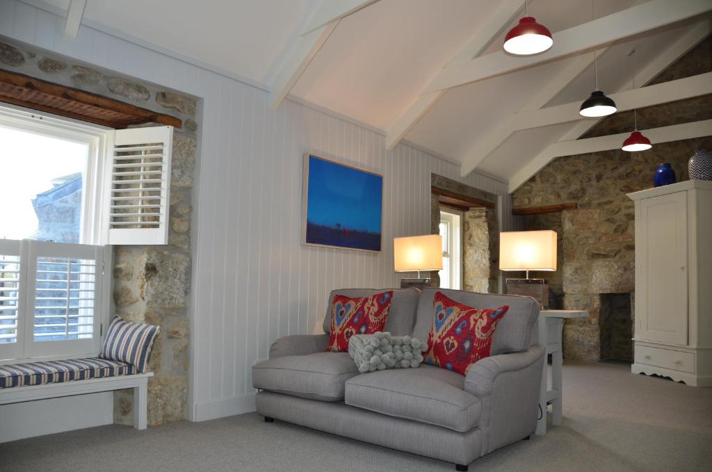 a living room with a couch and a window at Sunny Corner in Mousehole