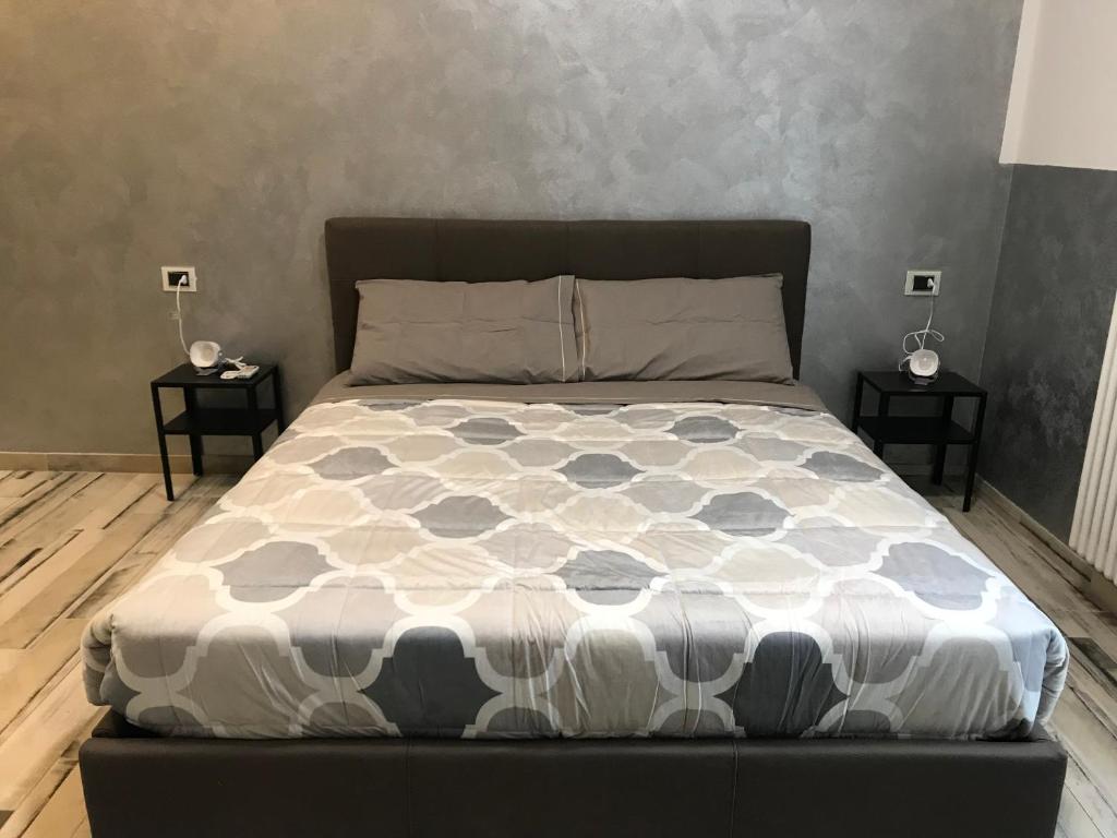 łóżko w sypialni z dwoma stolikami w obiekcie B&B ATTICO GALLIERA w Bolonii