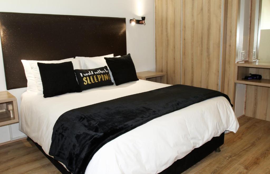 sypialnia z dużym łóżkiem z czarnym zagłówkiem w obiekcie 205 New Cumberland w Kapsztadzie