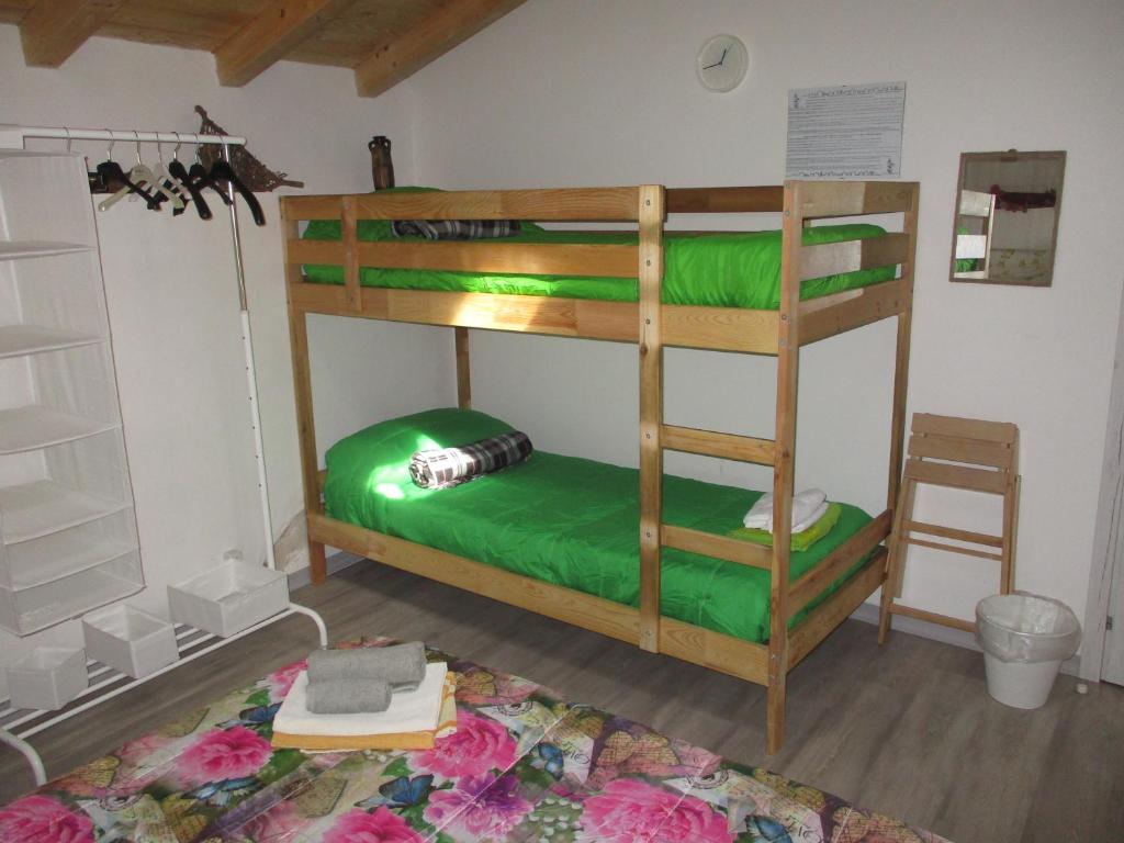 a room with two bunk beds with green sheets at Palazzo Ruisi in Scordia