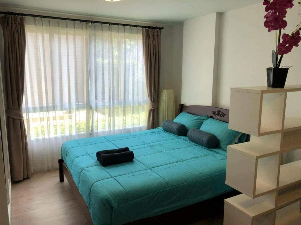 ホアヒンにあるBaan Peang Ploen Huahinのベッドルーム1室(窓の前に青いベッド1台付)