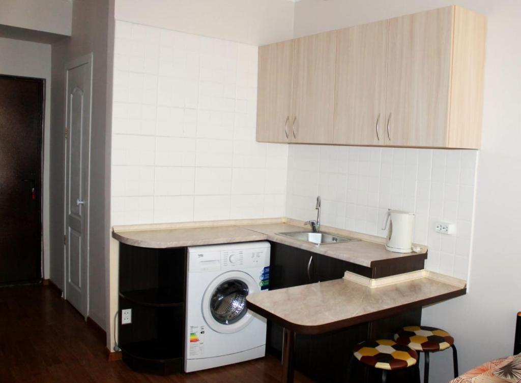 cocina con lavadora y fregadero en Apartments Zhambyl 159, en Almaty