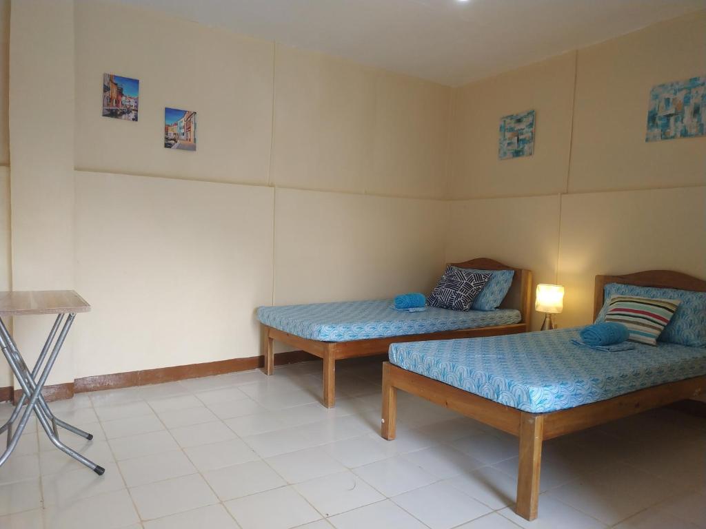 a room with two beds and a tripod at Nelmann's Nipa Huts in San Vicente