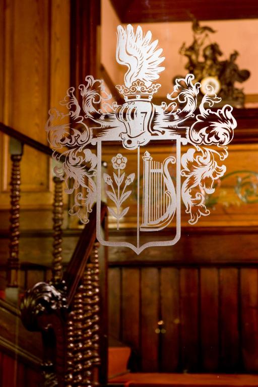 a white cross with a crest on a wall at Boutique Hotel Victoria Budapest in Budapest