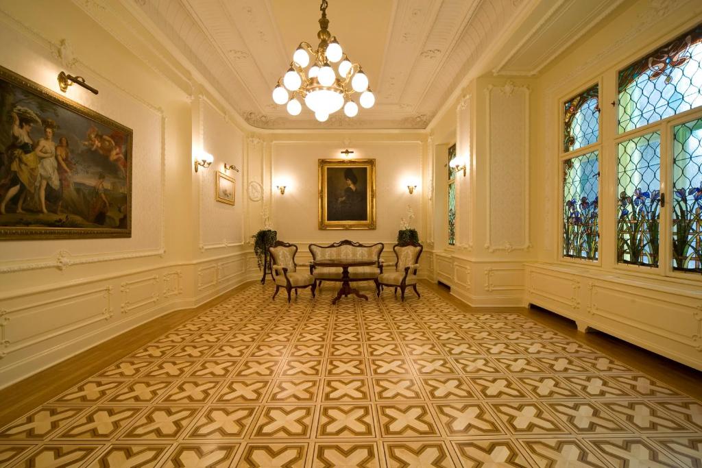 a hallway with a table and chairs in a building at Boutique Hotel Victoria Budapest in Budapest