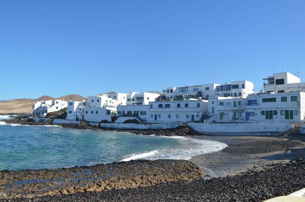 een groep witte gebouwen op een strand bij Casa Cabrera - 2 apartamentos con vistas al mar in Caleta de Caballo