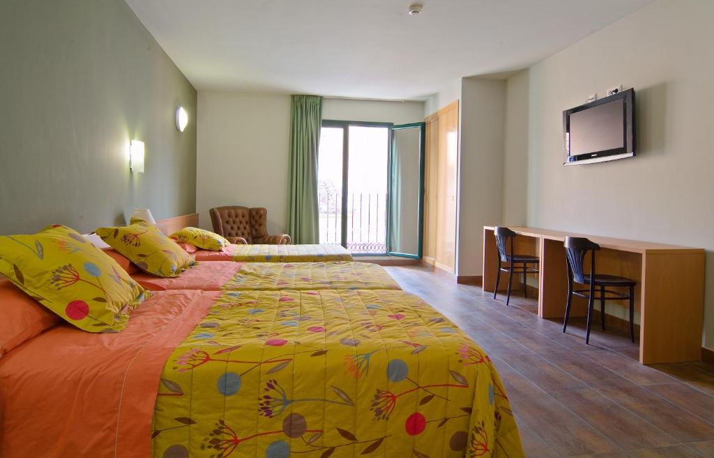 a hotel room with a large bed and a desk at Hotel Pinxo in Santa Coloma de Farners