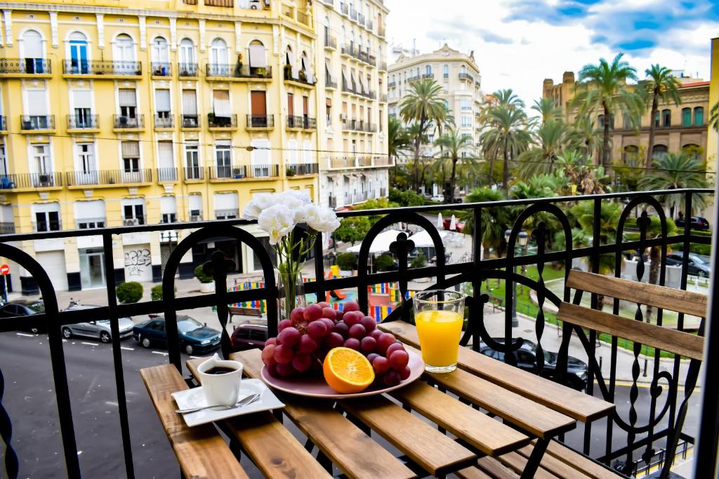 a plate of fruit on a table on a balcony at Valencia Apartamentos Goya in Valencia