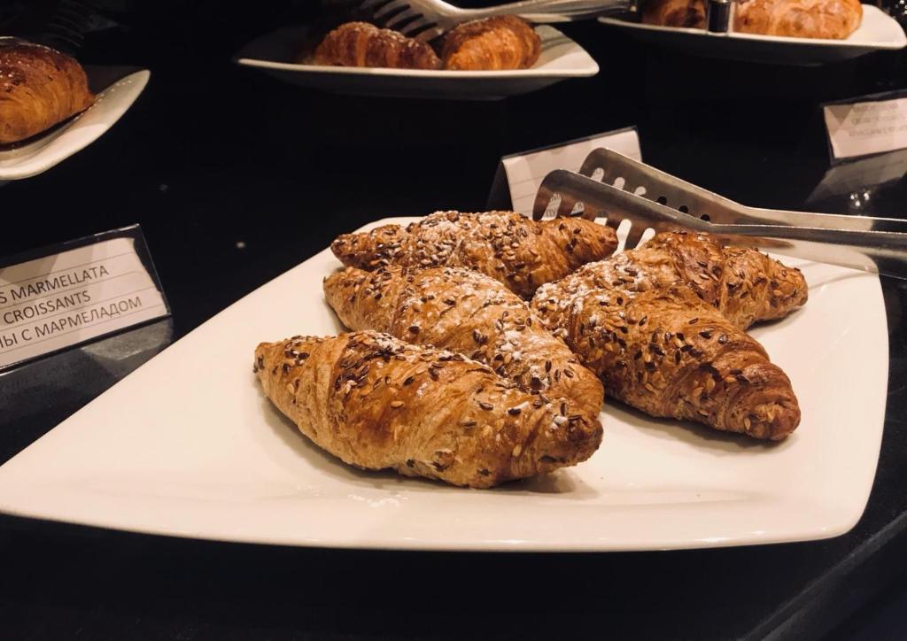 a white plate with croissants and other pastries at Hotel Principe di Piemonte in Rimini