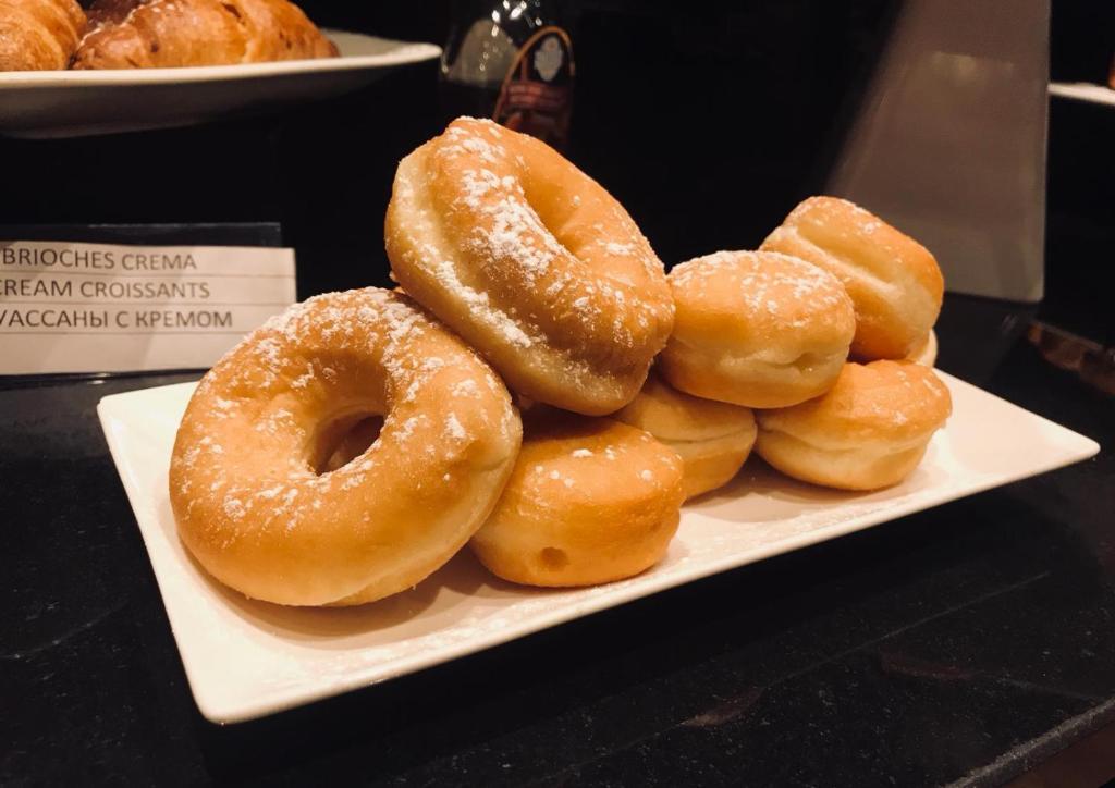 a pile of donuts on a plate on a table at Hotel Principe di Piemonte in Rimini