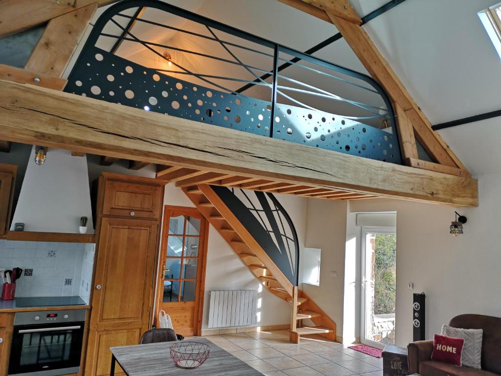 een verbouwde loft met een trap in een huis bij Les gîtes d'Herquetot "Les Genets" in Vasteville