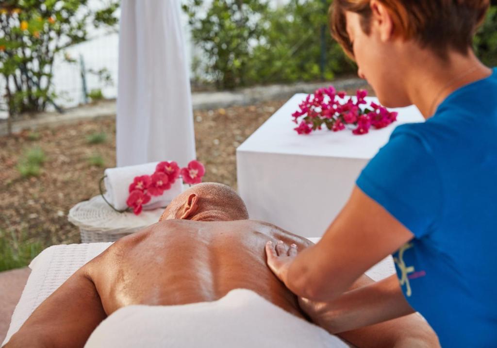a woman is giving a man a massage at VOI Marsa Siclà Essentia in Sampieri