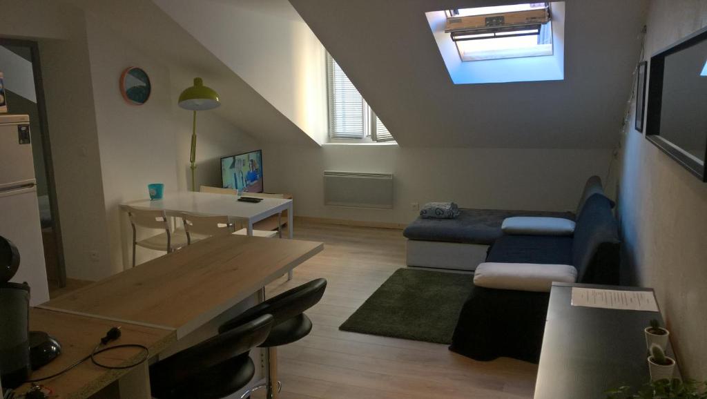 a small living room with a table and a couch at Rent4night Grenoble Europole in Grenoble