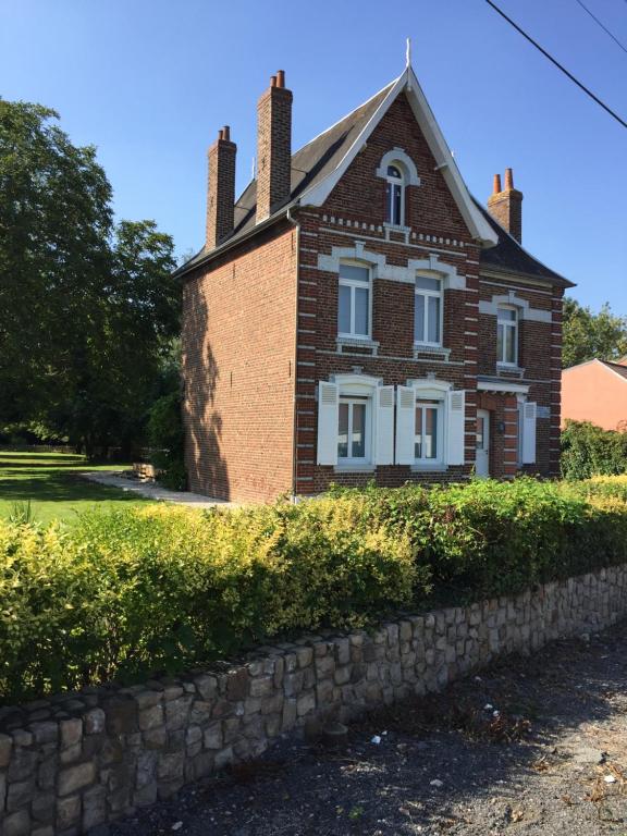 a brick house with a stone wall in front of it at La '1923' in Locon