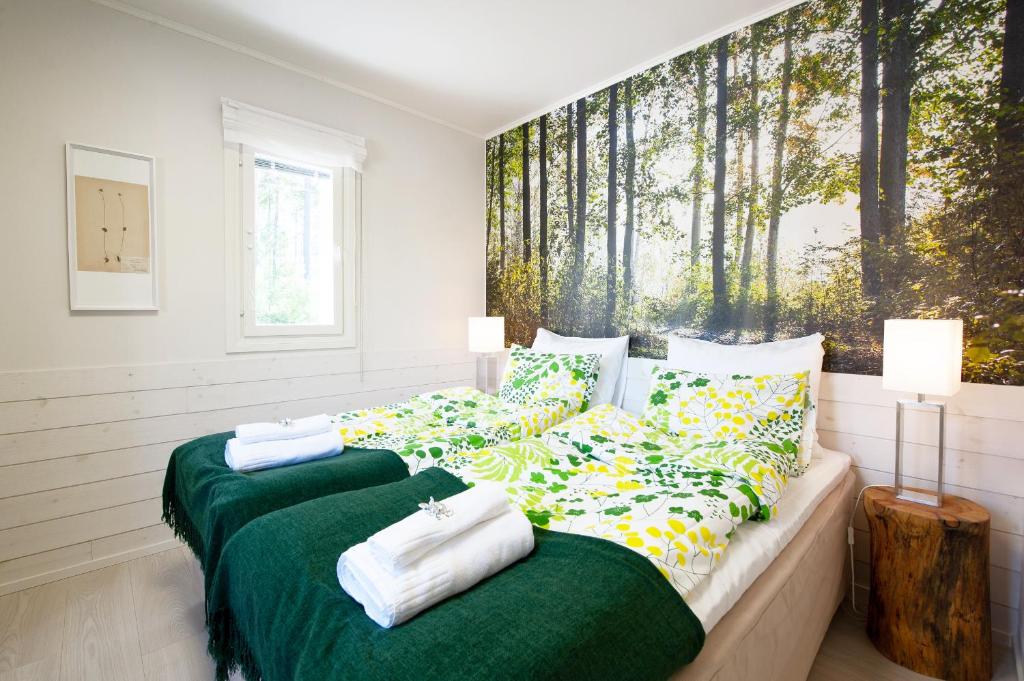 a bedroom with two beds with green and white pillows at Hotel Hiisi Hill in Jämsä