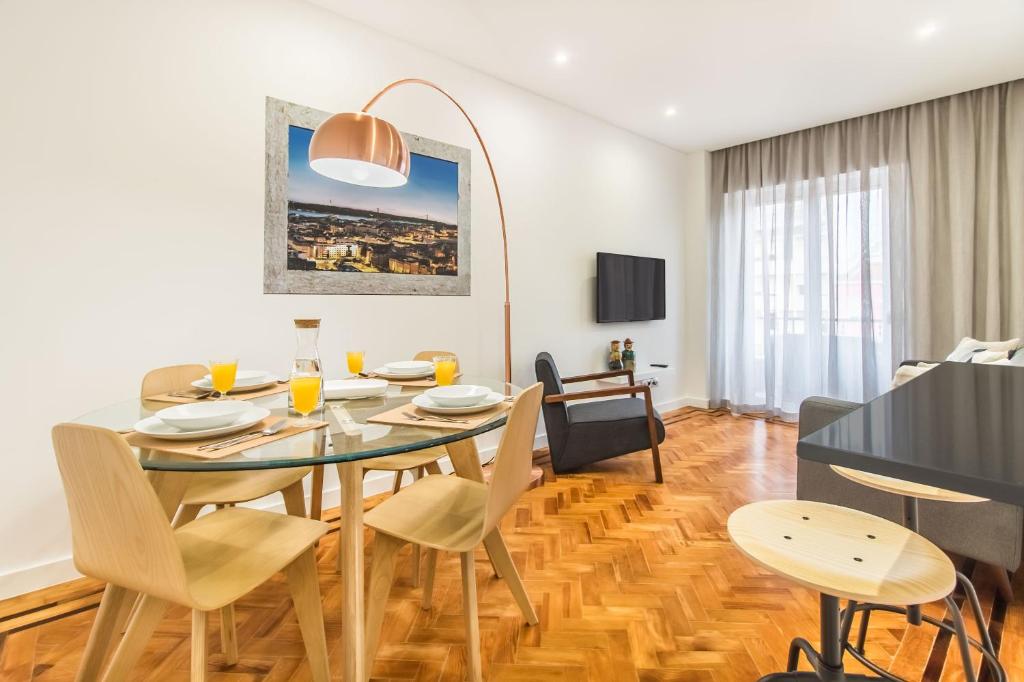 uma sala de jantar e sala de estar com mesa e cadeiras em Marquês de Pombal Metropolitan Flat em Lisboa