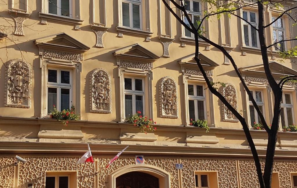 un edificio amarillo con ventanas y flores. en Homely Apartment's Old Town en Cracovia