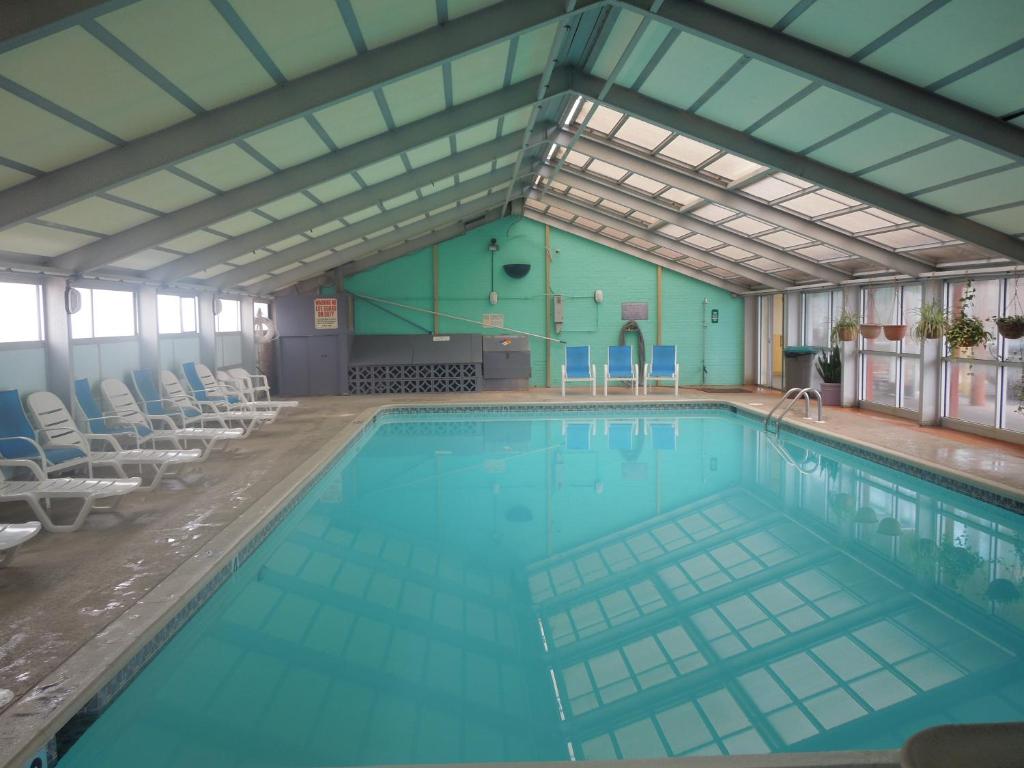 a large swimming pool with chairs in a building at Seahawk Motel in Virginia Beach