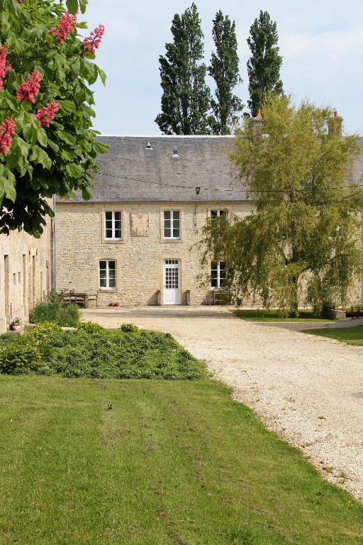 une ancienne maison en pierre avec une allée en gravier dans l'établissement Ferme Hay Day, à Asnières-en-Bessin