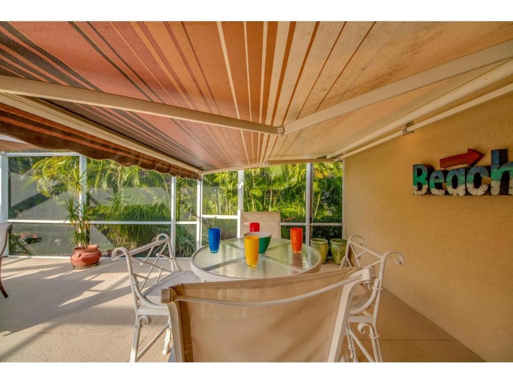 a table and chairs in a room with a porch at Villa Hideaway, Cape Coral in Cape Coral