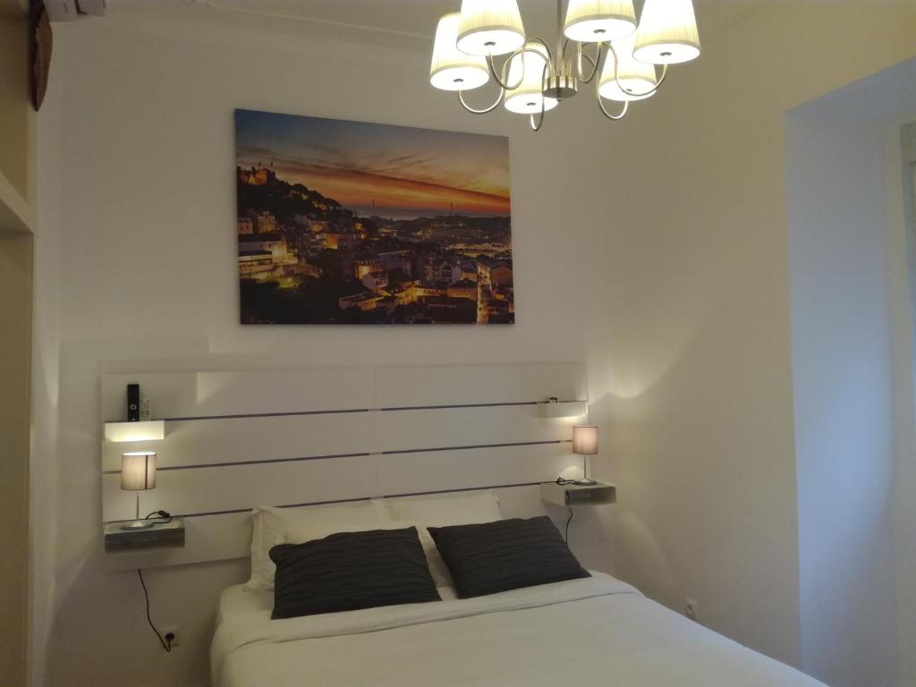 リスボンにあるFlor Lizのベッドルーム1室(ベッド1台付)が備わります。壁には絵画が飾られています。