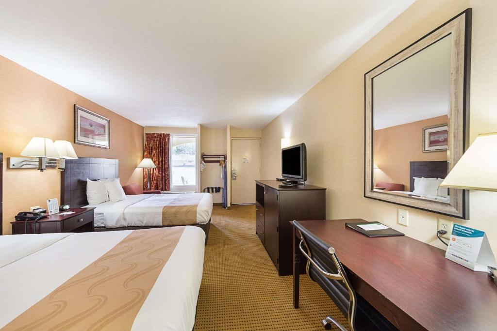 ein Hotelzimmer mit 2 Betten und einem Schreibtisch in der Unterkunft McIntosh Inn in Media