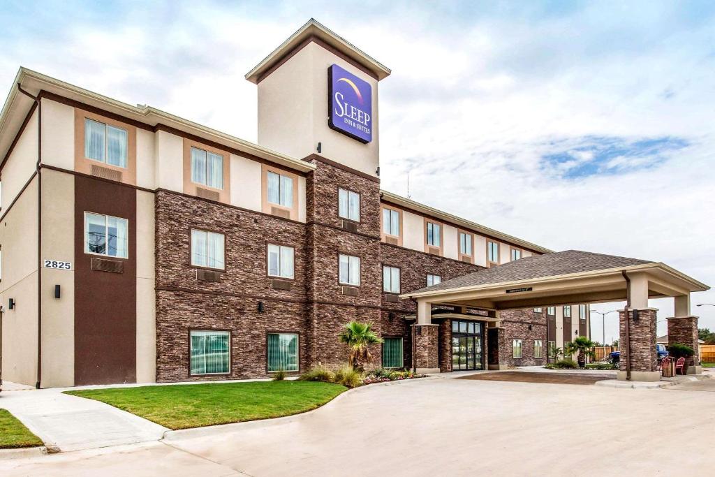 um hotel com um sinal ao lado em Sleep Inn & Suites - Bryan em Bryan