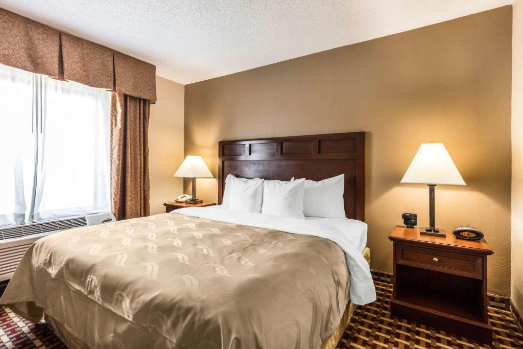 a hotel room with a large bed and a window at Quality Suites Paducah I-24 in Paducah