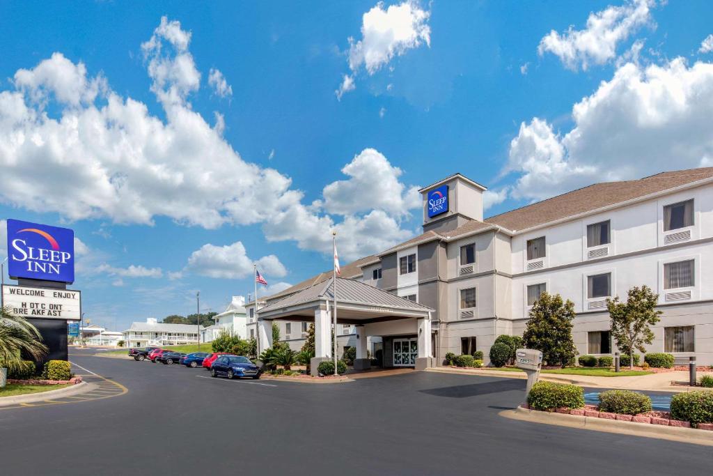 uma vista frontal de um hotel com carros estacionados num parque de estacionamento em Sleep Inn & Suites Millbrook - Prattville em Millbrook