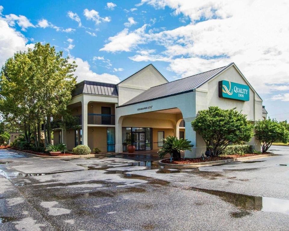 a front view of a hotel with a parking lot at Quality Inn Foley in Foley