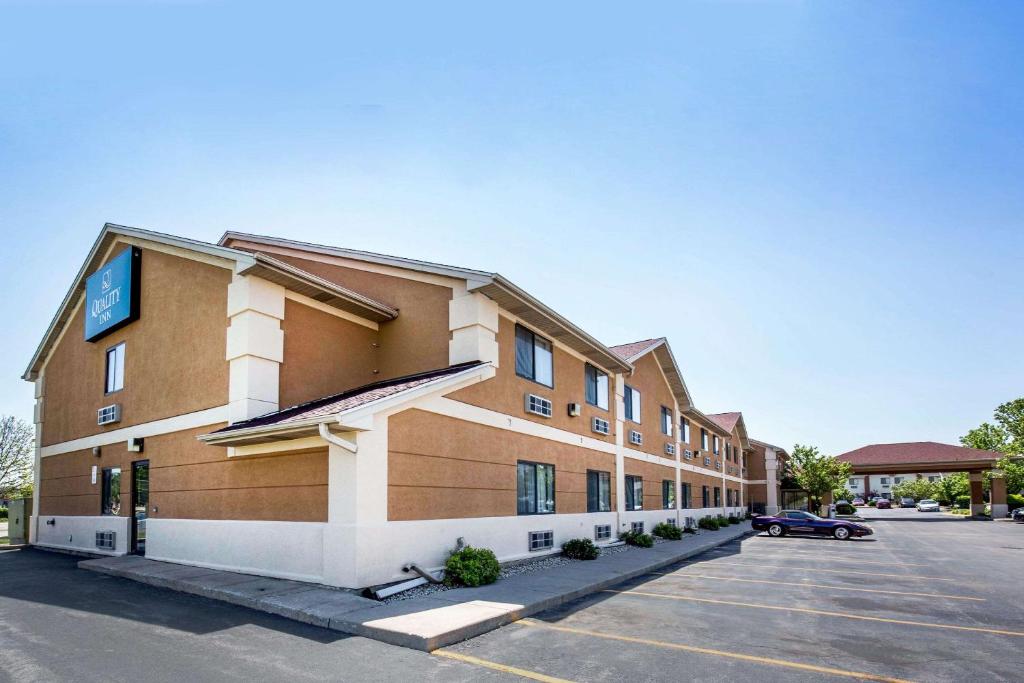 a building with a car parked in a parking lot at Quality Inn Monee I-57 in Monee