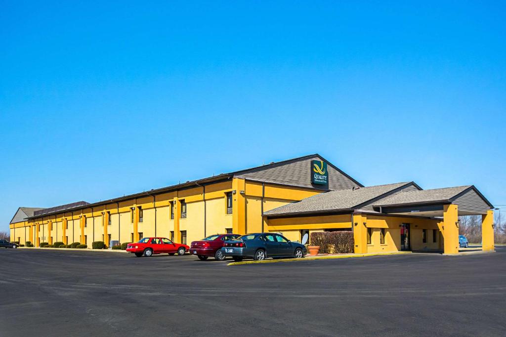 un edificio amarillo con coches estacionados en un estacionamiento en Quality Inn & Suites Greensburg I-74, en Greensburg