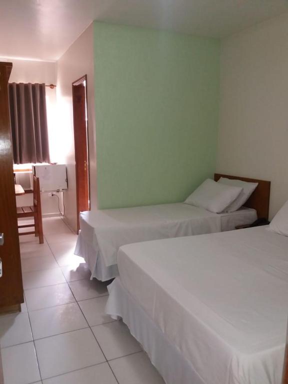 Postel nebo postele na pokoji v ubytování Ipê Guaru Hotel