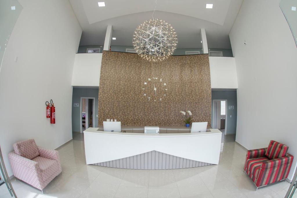 a lobby with a chandelier and two chairs at HOTEL HPR in Vitorino