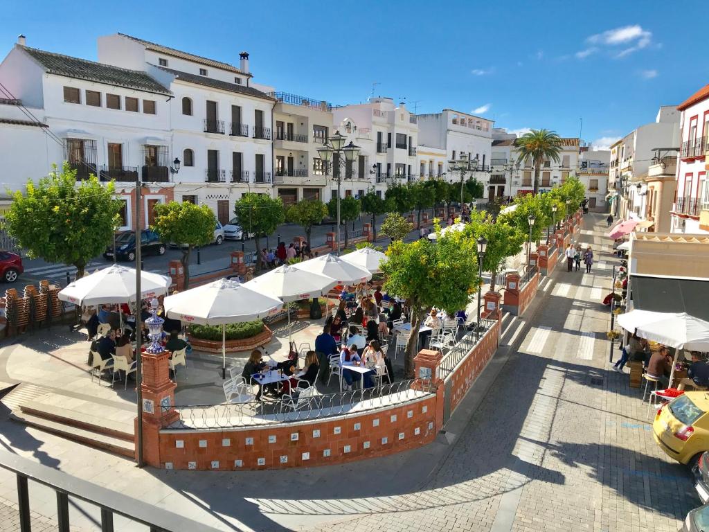 una calle con gente sentada en mesas y sombrillas en Calle Valenzuela 9 La Rambla, en La Rambla