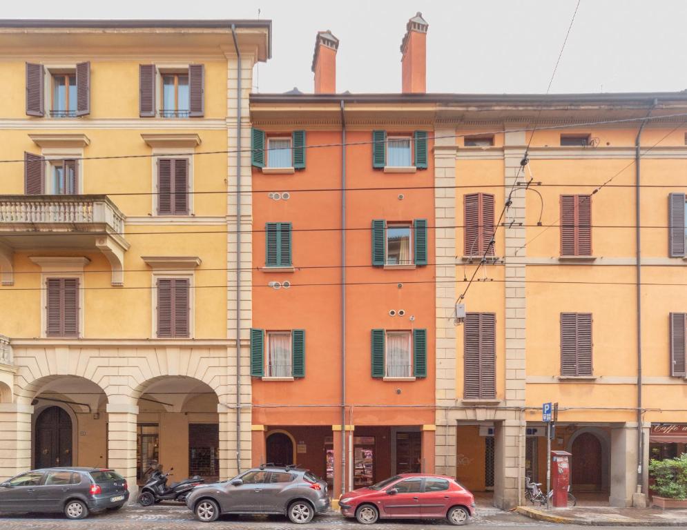 un grupo de edificios con coches estacionados frente a ellos en Santo Stefano Apartments - BolognaRooms, en Bolonia